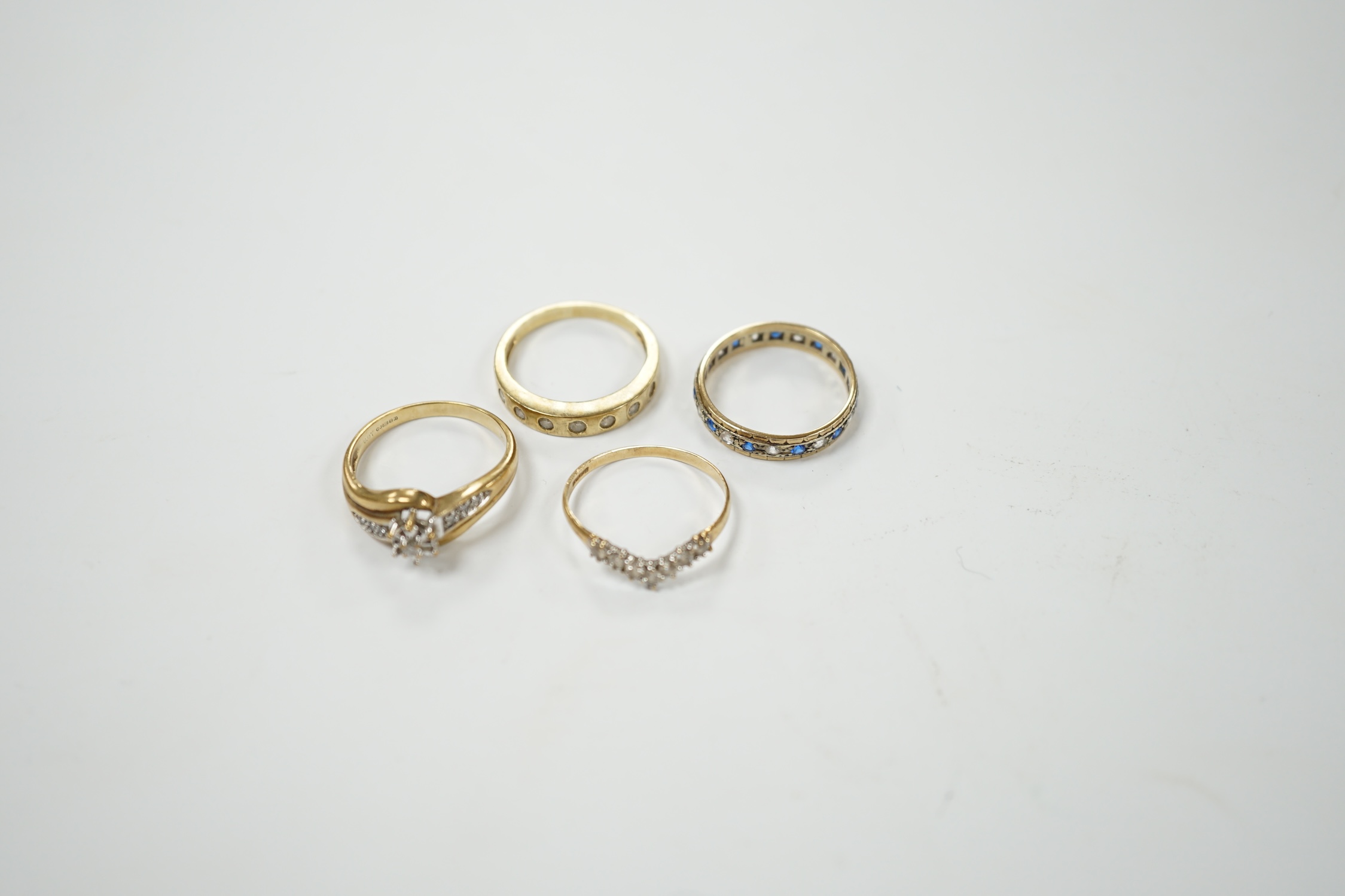 Two modern 9ct gold and diamond set rings and a 9ct gold, simulated diamond set chevron shaped ring and one other 9ct and paste set band, gross weight 9 grams. Condition - poor to fair